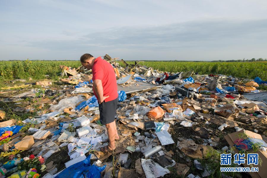 　7月19日,在烏克蘭頓涅茨克州,一名當?shù)孛癖娬驹隈R航MH17航班墜機現(xiàn)場。