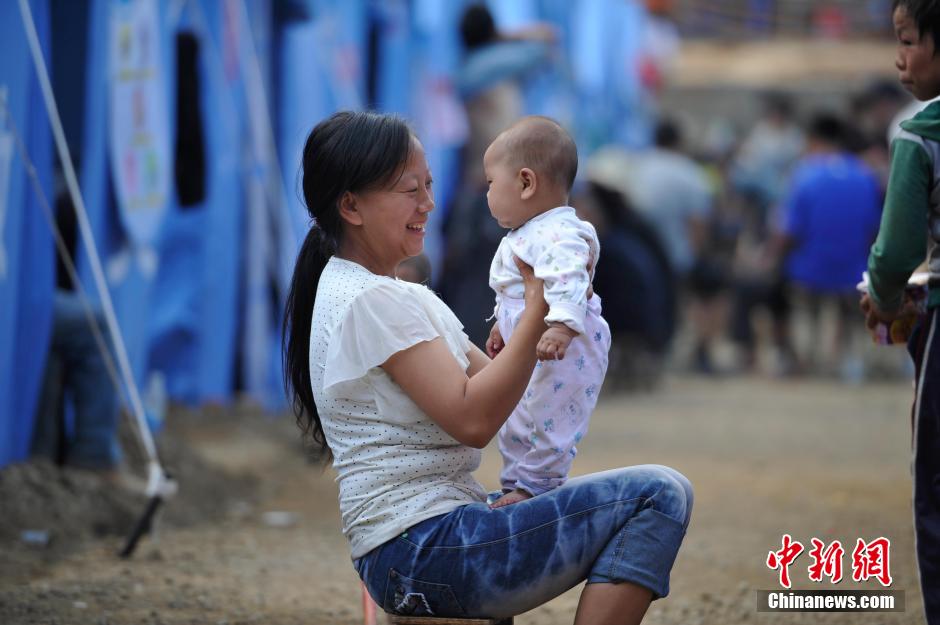 8月6日，一名年輕的母親在和孩子玩樂。
