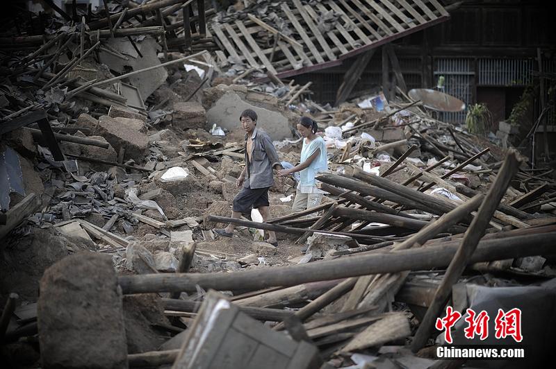 2014年8月5日，云南昭通龍頭山鎮(zhèn)老街，一對夫妻從居住房屋的廢墟中走過。