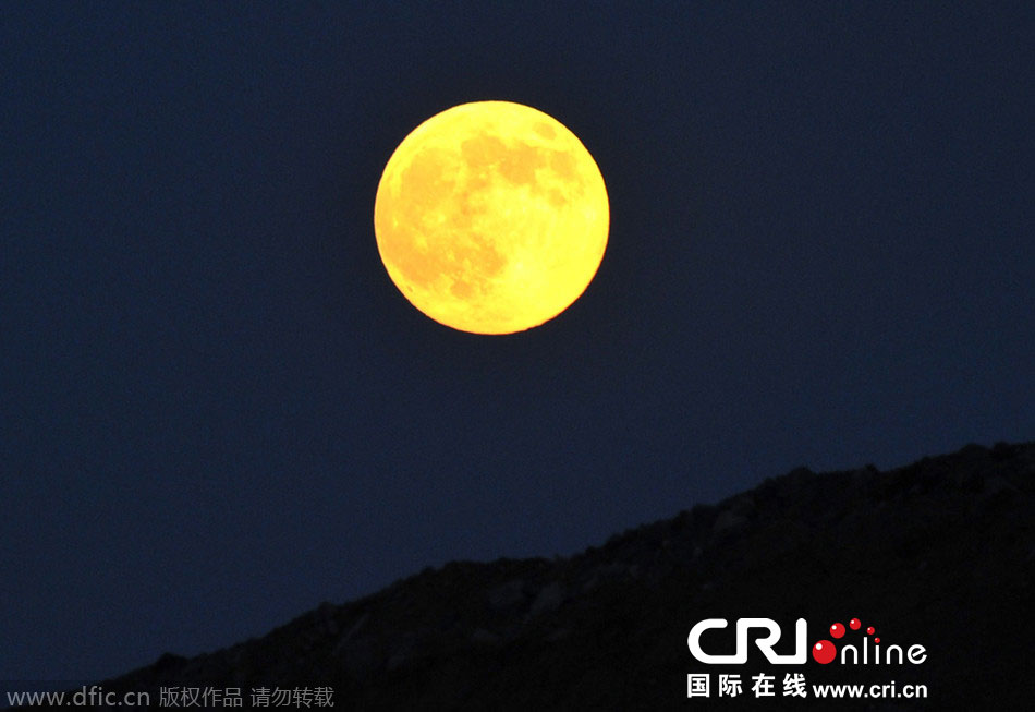 8月10日晚，一輪金燦燦的大月亮在遼寧省大連市東方升起。圖片來源：劉德斌/東方IC