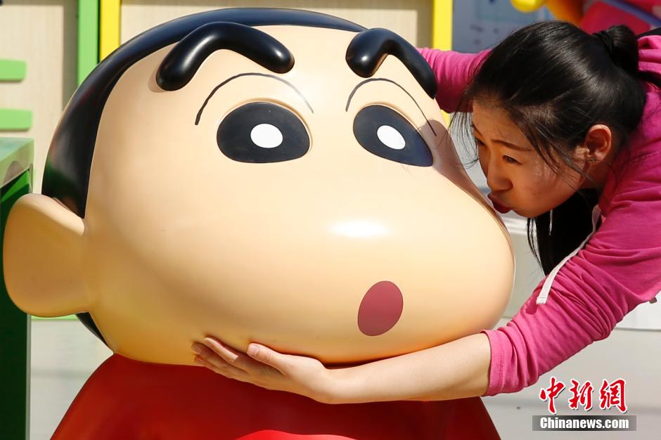 4月22日，游客與蠟筆小新合影?！跋灩P小新25周年紀(jì)念特展”日前在北京開(kāi)展，吸引了不少市民游客。