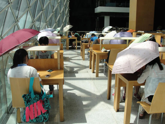 2015年8月2日，深圳圖書館，“太陽曬進(jìn)來很熱的，我們都要撐著傘讀書。”