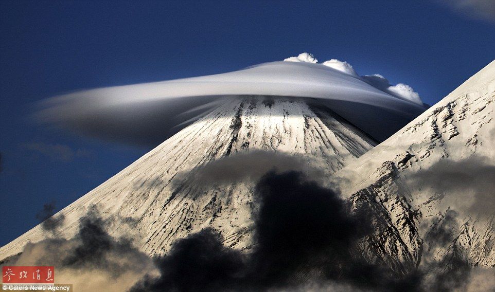 火山上籠罩著類似于外星飛碟形狀的云彩，場景猶如科幻大片。