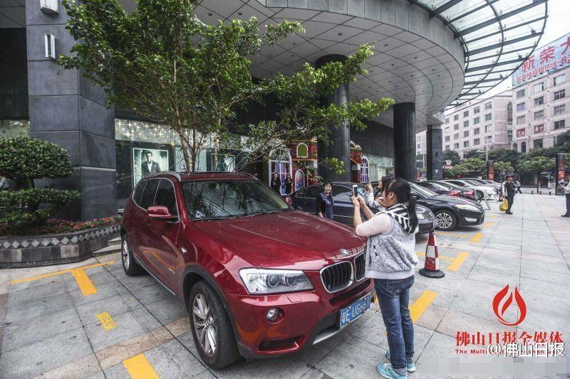 一輛停在停車(chē)位上的寶馬轎車(chē)，被墜落的樹(shù)枝砸中，樹(shù)枝徑直插入車(chē)內(nèi)，現(xiàn)場(chǎng)引發(fā)不少市民圍觀拍照。