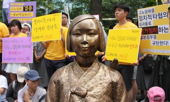 7月2日，在韓國首爾的日本駐韓國大使館前，民眾在慰安婦少女像旁手持標(biāo)語參加抗議活動。