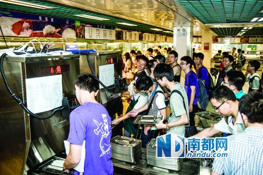昨日，華南理工大學(xué)一食堂內(nèi)，學(xué)生們正在使用新安裝的自動(dòng)打飯機(jī)打飯。中新社發(fā)
