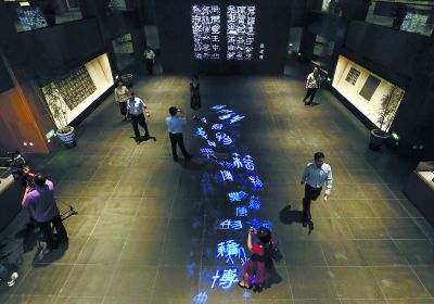 昨天，在國(guó)家典籍博物館內(nèi)，通過(guò)藝術(shù)投影技術(shù)呈現(xiàn)在展廳地面上的“漢字歷史長(zhǎng)河”，引得參觀者駐足觀看。