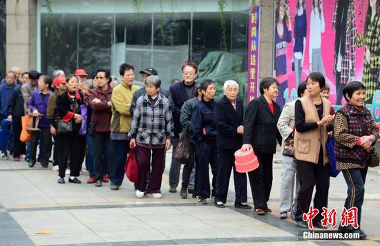 圖為10月28日，在江西九江市一家羊絨皮草服裝服飾博覽會現(xiàn)場，老人們正在頂著寒風(fēng)排隊等待領(lǐng)取10元代金劵。