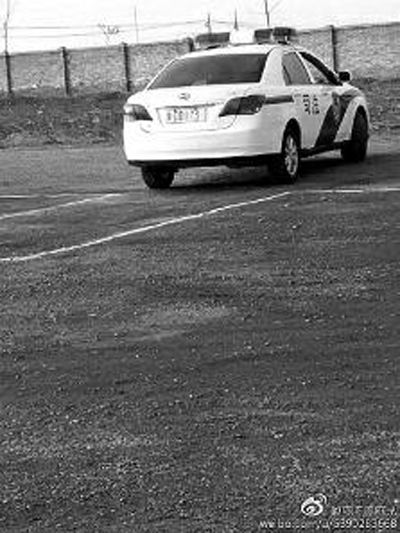一輛車牌號 為“ 陜DD173”的制式警車停在一個劃著白線的場地上，車身標有“司法”字樣