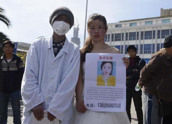 昆明火車站廣場上，24歲的黃習菊身穿潔白的婚紗，帶著身患白血病的弟弟征婚。