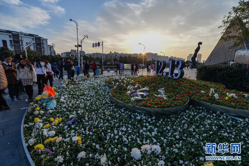 12月14日,觀眾在侵華日軍南京大屠殺遇難同胞紀(jì)念館前的“12·13”花壇上擺放鮮花祭奠遇難同胞。新華社記者 沈鵬 攝