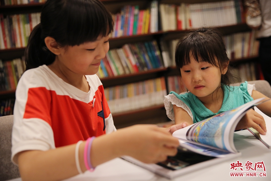 姐姐王藝茹，11歲，小學(xué)五年級學(xué)生；妹妹王有君，5歲：像喜歡看電視一樣喜歡看書。
