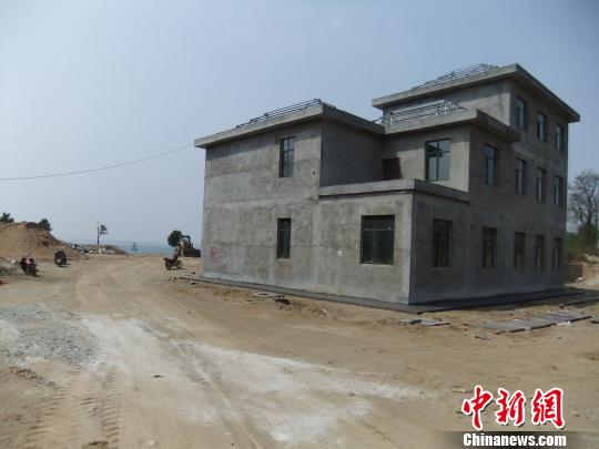 鴨河水庫庫區(qū)邊的新建別墅，一面墻上寫著“拆”，另一邊在加緊施工。吳揚(yáng)　攝