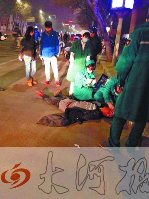 醉漢躺在地上，醫(yī)護(hù)人員對(duì)其進(jìn)行檢查。